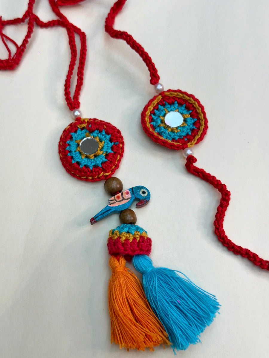 Parrot Petal Duo – Handcrafted Mirror & Parrot Crochet Rakhi Set